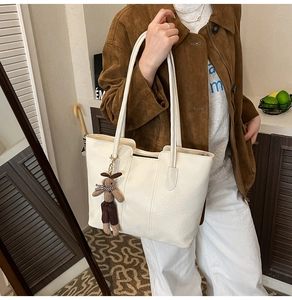 Vue détaillée du grand sac cabas blanc en similicuir avec un pendentif lapin peluche