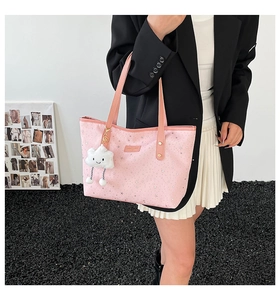 Detail of pink tote bag with star prints and cute cloud plush charm on handle