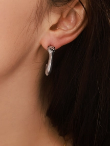 Vue détaillée de boucles d'oreilles serpent argentées avec texture d'écailles en acier