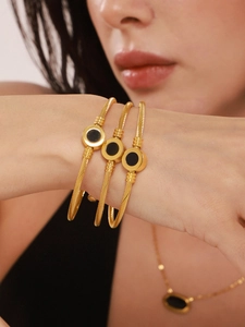 Detailed shot of gold-plated cable texture bracelets and necklace with black inlays