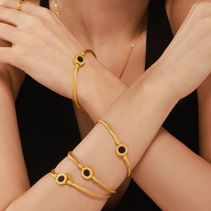 Gold cable cuff bracelet set with black shell inlay and 18K PVD plating on a model