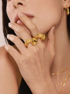 Close-up of wavy 18K gold plated multi-finger ring with matching jewelry on model