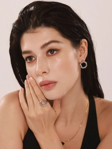 Gros plan de boucles d'oreilles et bague géométriques en métal liquide argenté