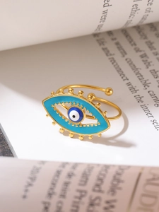 Detailed close-up of golden evil eye ring on an open book page with warm lighting