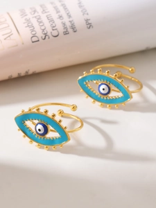Detail of gold evil eye rings with blue enamel and textured beads in elegant setting