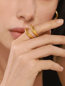 Close-up of a gold minimalist irregular ring with polished finish on model finger