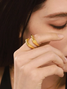 Close-up of minimalist 18K gold plated wavy ring with a high-polished mirror finish