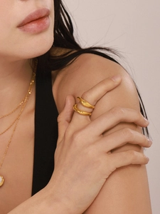 Detailed close-up of golden irregular geometric stainless steel ring on model finger