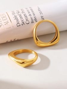 Macro detail of high-polish PVD gold irregular twisted stainless steel rings