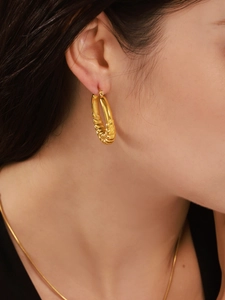 Detailansicht der 18K vergoldeten Croissant-Ohrringe mit elegantem Spiralmuster am Model