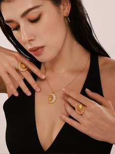 Detail of 18K gold celestial jewelry set with sun moon pendants and zircon rings