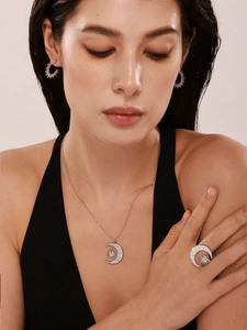 Model wearing a sun and moon jewelry set in polished silver with shimmering cubic zirconia