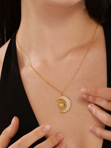 Close-up of gold titanium sun and moon pendant necklace with zircon pavé setting