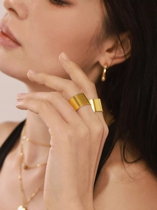 Gros plan de bagues larges plaquées or minimalistes et parure de bijoux sur un mannequin