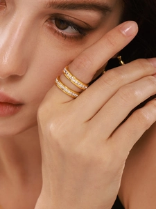Close-up of dual gold stackable rings featuring pavé rectangular cubic zirconia stones
