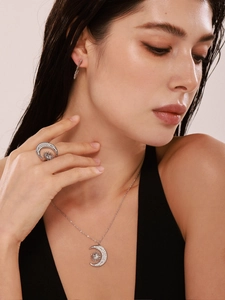 Close-up of sparkling sun and moon necklace with ring set featuring inlaid zircons