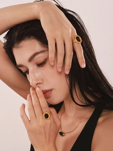 Close-up of vintage gold-plated rings and necklace with oval black onyx gemstones