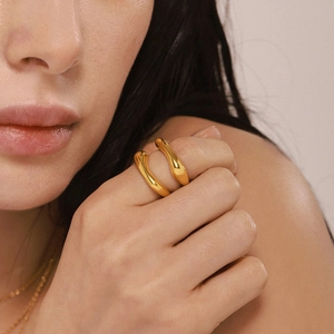 Minimalist irregular twisted gold-plated stainless steel ring worn on a female model
