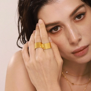 Bague large minimaliste avec finition dorée PVD et texture mate portée par un mannequin