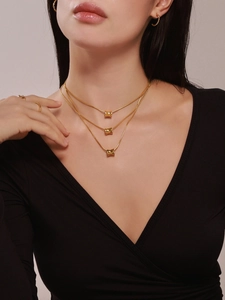 Detailopname van drielaagse 18K vergulde halsketting met cilindervormige hanger