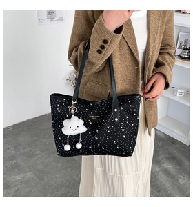 Detail of star print tote bag with cute cloud charm and fashion label on canvas