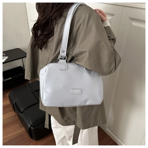 Détail du sac Boston en cuir gris clair avec large bandoulière et boucle en argent