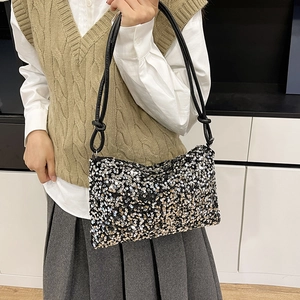 Chic dumpling handbag with gold and silver sequins and black leather knotted straps