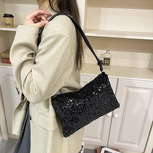 Chic black sequined underarm bag with knotted leather strap and glossy finish