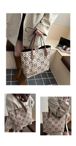 Macro detail of monogram pattern leather tote bag with gold M-letter metal pendant charm