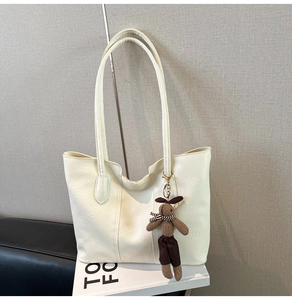 Détail du sac cabas en similicuir crème avec un joli charm de lapin en peluche