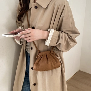 Caramel minimalist faux suede shell crossbody bag with pleated opening on a model