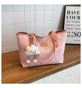 Dettaglio borsa tote rosa con stelle argentate, manici in pelle e charm a nuvola
