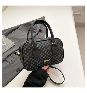 Détail d'un sac à main gris foncé avec imprimé texturé et logo en métal doré
