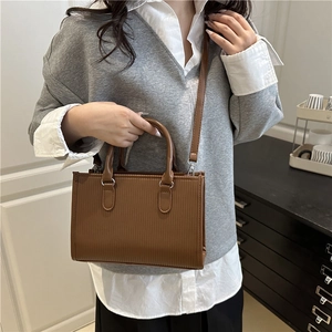 Brown rectangular crossbody bag with vertical striped embossing and dual handles