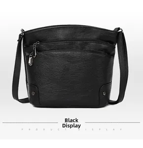 Macro detail of black pebble leather texture and metal rivets on multi-layer crossbody bag
