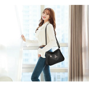 Classic black leather tote bag with gold kangaroo hardware for middle-aged women