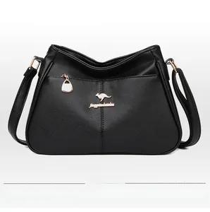 Detail of black pebbled leather tote bag featuring gold kangaroo logo and adjustable strap