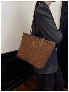Detailed view of leopard print tote bag with gold lettering and leather shoulder strap