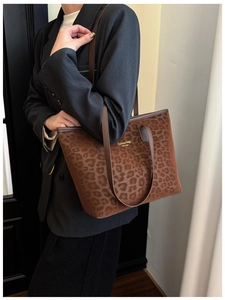 Close-up of leopard print tote bag with gold lettering and brown shoulder straps