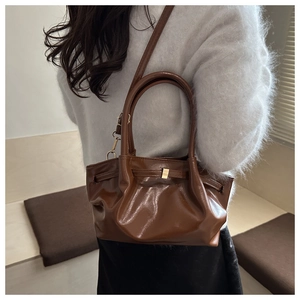 Detail of vintage brown pleated handbag showing textured PU leather and golden hardware
