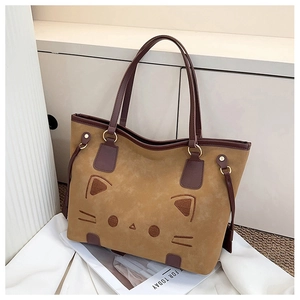 Detail of camel faux suede tote bag featuring delicate cat face embroidery and gold hardware