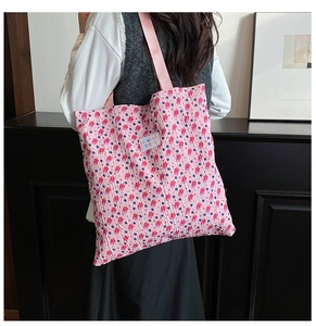 Detailed view of floral tote bag with textured pink fabric and comfortable shoulder strap