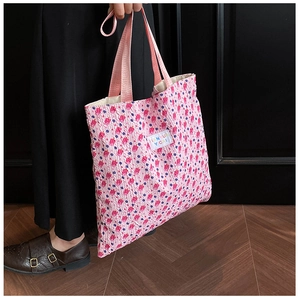 Detail of pink floral tote bag showing textured seersucker fabric and brand label