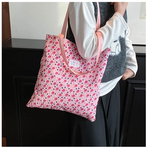 Close-up of pink floral tote bag with textured bubble fabric and woven shoulder strap