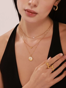 Détail du collier triple rang plaqué or 18 carats avec pendentif phénix et breloques étoiles