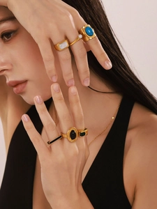 Detailed view of vintage gold rings set with zircon and pearls on a model hand