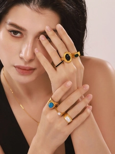 Close-up of bohemian gold rings with turquoise and pearls on model hands