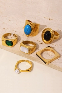 Detailed set of vintage gold-tone rings featuring turquoise, pearls, and colorful gemstones