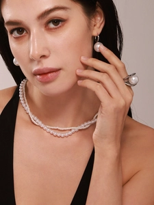 Gros plan d'un élégant collier de perles double rang et boucles d'oreilles sur un mannequin