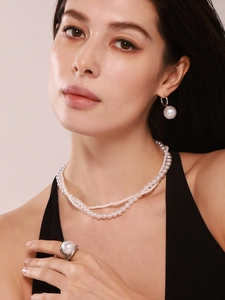 Gros plan d'un élégant collier de perles double rangée, boucles et bague sur un mannequin